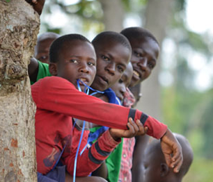 children peeking from behind a tree